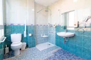 a bathroom with a toilet and a sink and a shower at Hotel Sagunto in Sagunto