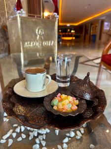 Askoc Hotel & SPA في إسطنبول: طاولة مع كوب من القهوة وصحن من الحلوى
