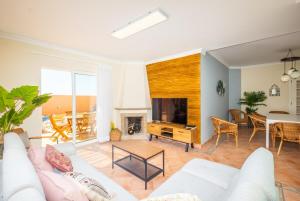 a living room with a white couch and a tv at Villa alhabu in Albufeira