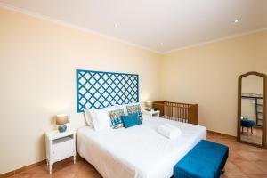 a bedroom with a large white bed and a mirror at Villa alhabu in Albufeira