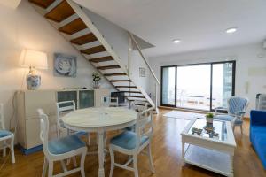 - un salon avec une table et des chaises ainsi qu'un escalier dans l'établissement rentafive Nuevo AA Reformado Piscina, à Gran Alacant