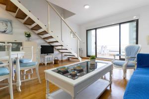 - un salon avec une table et des chaises ainsi qu'un escalier dans l'établissement rentafive Nuevo AA Reformado Piscina, à Gran Alacant
