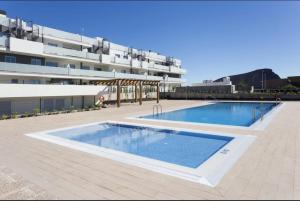 een groot zwembad voor een gebouw bij Great apartment penthouse 2 bedrooms Tejita Beach in El Médano