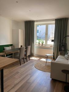 - un salon avec une table, des chaises et un canapé dans l'établissement Haus am Stadttor, à Hattingen