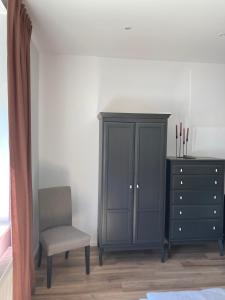 a bedroom with a cabinet and a chair and a dresser at Haus am Stadttor in Hattingen