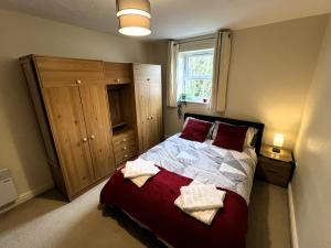 ein Schlafzimmer mit einem Bett mit zwei Handtüchern darauf in der Unterkunft Spacious 2BR Flat with Sofa-Bed in Central Reading in Reading