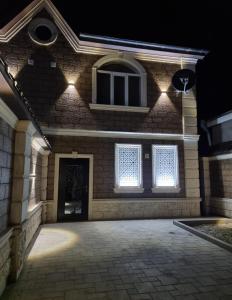 a house with lights on the front at night at Beautiful Villa in Qusar