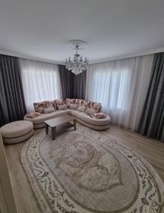 uma sala de estar com um sofá e uma mesa em Beautiful Villa em Qusar