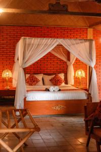 - une chambre avec un lit à baldaquin dans l'établissement Rajaklana Resort and Spa, à Bantul