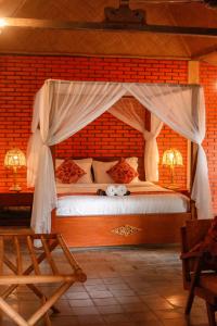 a bedroom with a bed with a canopy at Rajaklana Resort and Spa in Bantul