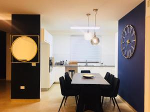 a dining room with a table and a clock on a wall at Harav Kuk Royal Suites - Alefimmoed in Jerusalem
