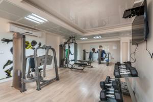 a gym with several tread machines and a man in the background at Harav Kuk Royal Suites - Alefimmoed in Jerusalem