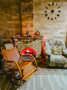 a living room with a fireplace with a chair and christmas lights at Phoenix Villa in Zarritʼapʼ