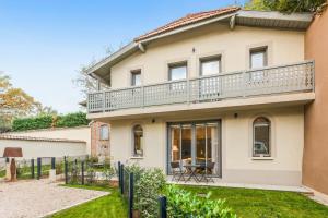 a house with a balcony on top of it at La Villa Serenna - Appt avec jardin, 15 mn de Lyon in Écully