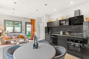 cocina y sala de estar con mesa blanca y sillas en La Villa Serenna - Appartement avec jardin, en Écully