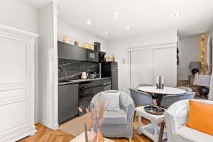 cocina y sala de estar con mesa y sillas en La Villa Serenna - Appartement avec jardin, en Écully