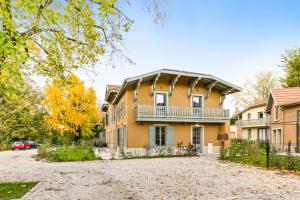 a large yellow house with a driveway at La Villa Serenna - Appartement avec jardin in Écully