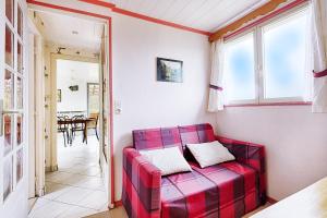 ein rotes Sofa im Wohnzimmer mit einem Tisch in der Unterkunft Le Chalet Sous les Sapins - Superbe vue in Rochesson