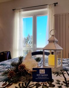 a table with a candle and a lantern on a bed at MUN Apartment - Major Unforgettable Nights in Fuipiano Valle Imagna