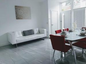 a white living room with a table and a couch at Spacious 4 Bedroom House in Leamington Spa