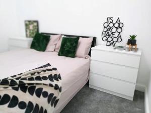 a bedroom with two white dressers and a bed at Spacious 4 Bedroom House in Leamington Spa