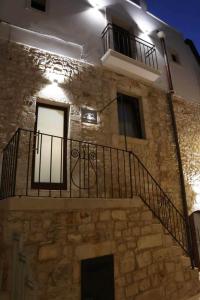 Edificio de piedra con escalera y balcón en La Casetta b & b en Turi