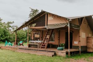 una casa con un porche con una escalera y una mesa en Kampari, en Delfstrahuizen