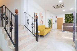 a living room with stairs and a yellow couch at Hotel Sagunto in Sagunto