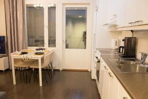 a kitchen with a small table and a kitchen with a window at Lahti Furn House in Lahti