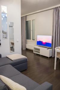 a living room with a couch and a flat screen tv at Lahti Furn House in Lahti