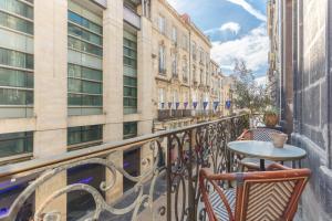 uma varanda com uma mesa, cadeiras e edifícios em LA Sainte Catherine 215 em Bordéus