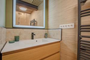 ein Bad mit einem Waschbecken und einem Spiegel in der Unterkunft LA Sainte Catherine 215 - Place de Parking in Bordeaux
