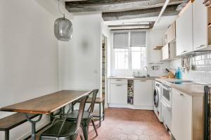 een keuken met een houten tafel en een tafel en stoelen bij Cosy studio à proximité du Musée du Louvre in Parijs