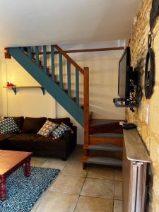 un soggiorno con divano e una scala di Le Chevrefeuille chambres d'hotes et gîtes de charme a Meyrals