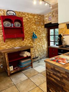 una cucina con mobile rosso con piatti di Le Chevrefeuille chambres d'hotes et gîtes de charme a Meyrals