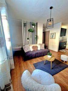 ein Wohnzimmer mit einem Sofa und einem Tisch in der Unterkunft Studio au cœur des Alpes et Parking gratuit in Crans-Montana