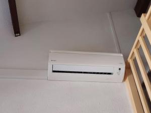 ein weißes Gerät, das auf dem Boden in einem Raum sitzt in der Unterkunft Studio Mezzanine Piscine presqu'île de Giens in Hyères