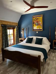 una camera con un grande letto e un ventilatore a soffitto di Le Chevrefeuille chambres d'hotes et gîtes de charme a Meyrals