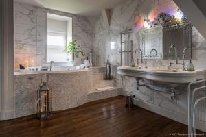 a large bathroom with two sinks and a tub and a mirror at Villa Alecya in Sainte-Catherine-de-Fierbois