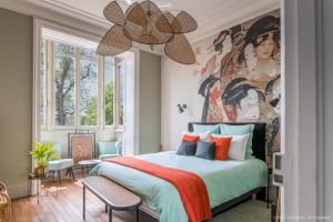 um quarto com uma cama com um quadro na parede em Villa Alecya em Sainte-Catherine-de-Fierbois