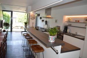 uma cozinha com um balcão longo e bancos num quarto em Casa Camino em Bruges