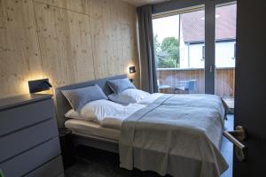 a bedroom with a large bed with a large window at Landurlaub mit neugierigen Blicken in den Pferdestall, eingezäuntem Garten, Kamin und Sauna in Rot am See