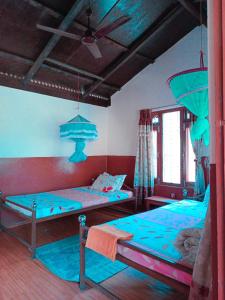 duas camas num quarto com azul em Hotel Tree Land em Sauraha