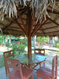 uma mesa e cadeiras debaixo de um guarda-chuva de palha em Hotel Tree Land em Sauraha