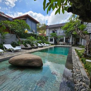 a pool with a rock in the middle of a house at Chandi Hotel Ubud in Ubud