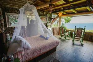 um quarto com uma cama e uma rede mosquiteira em Casa El Paraíso, Las Galeras em Las Galeras
