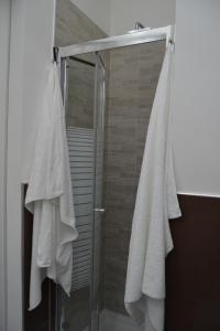 a shower with white towels hanging on a door at B&B Paolo e Mariella in Palermo