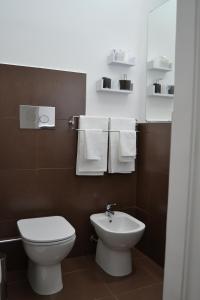 a bathroom with a toilet and a sink and towels at B&B Paolo e Mariella in Palermo