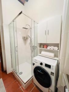 a shower with a washing machine in a bathroom at Il cretto bianco in Città di Castello