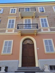 um edifício com uma porta de madeira e uma varanda em Residence del Centro em Modena